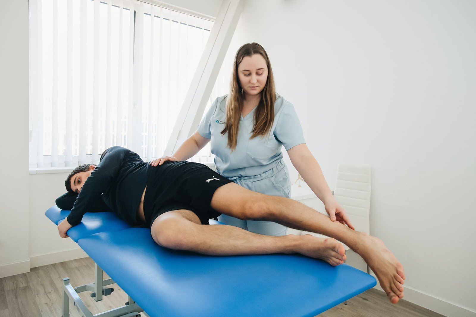 A rehabilitation professional guiding a client through an exercise in a clinic.
